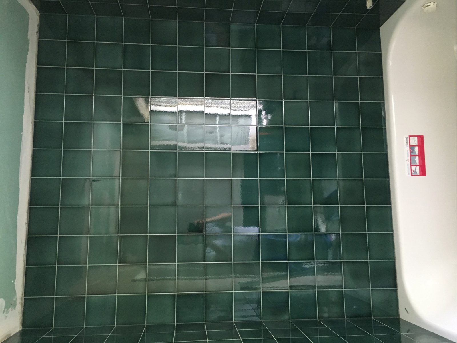 Dusche mit dunkelgrünen Wandplatten und Fugenbild