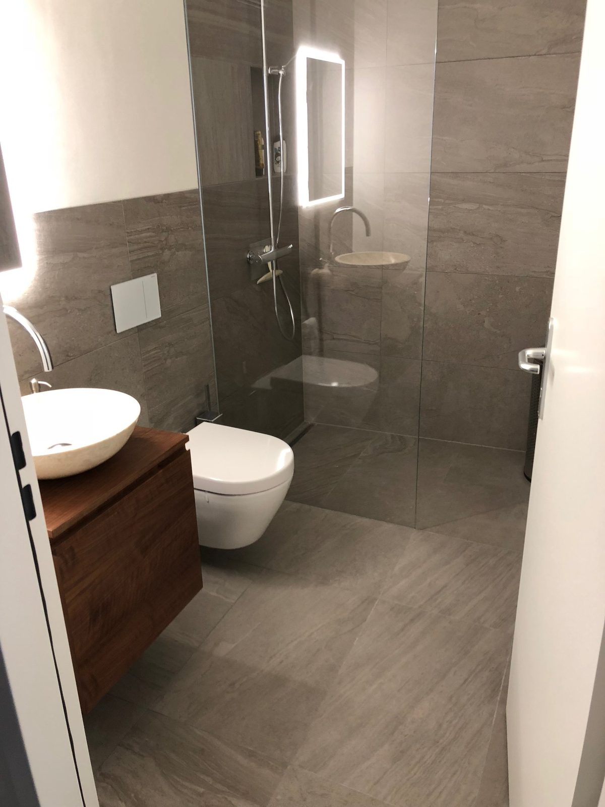 Dusche mit grossformatigen Feinsteinzeugplatten und Wandnische