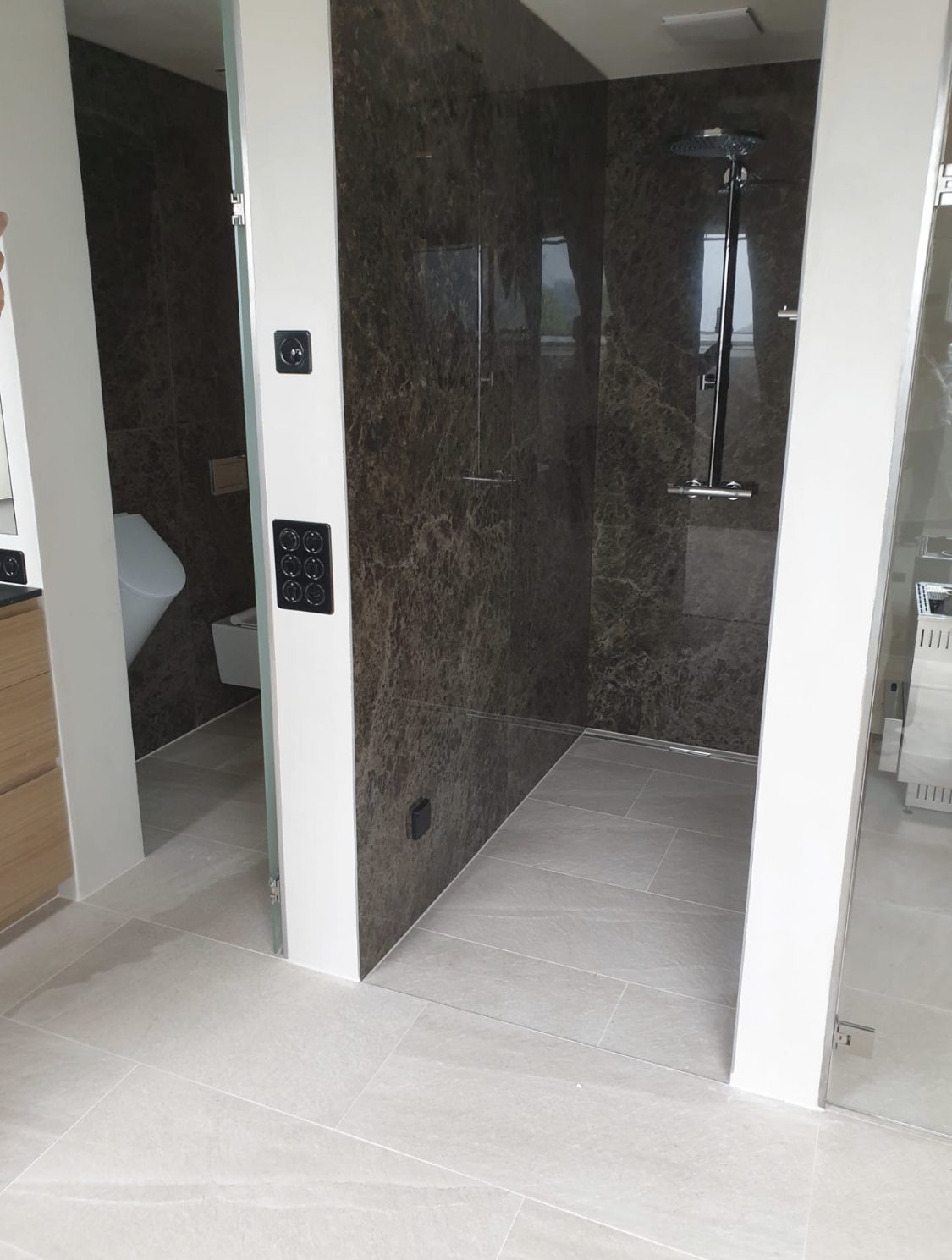 Walk-in-Dusche mit dunklen Natursteinplatten