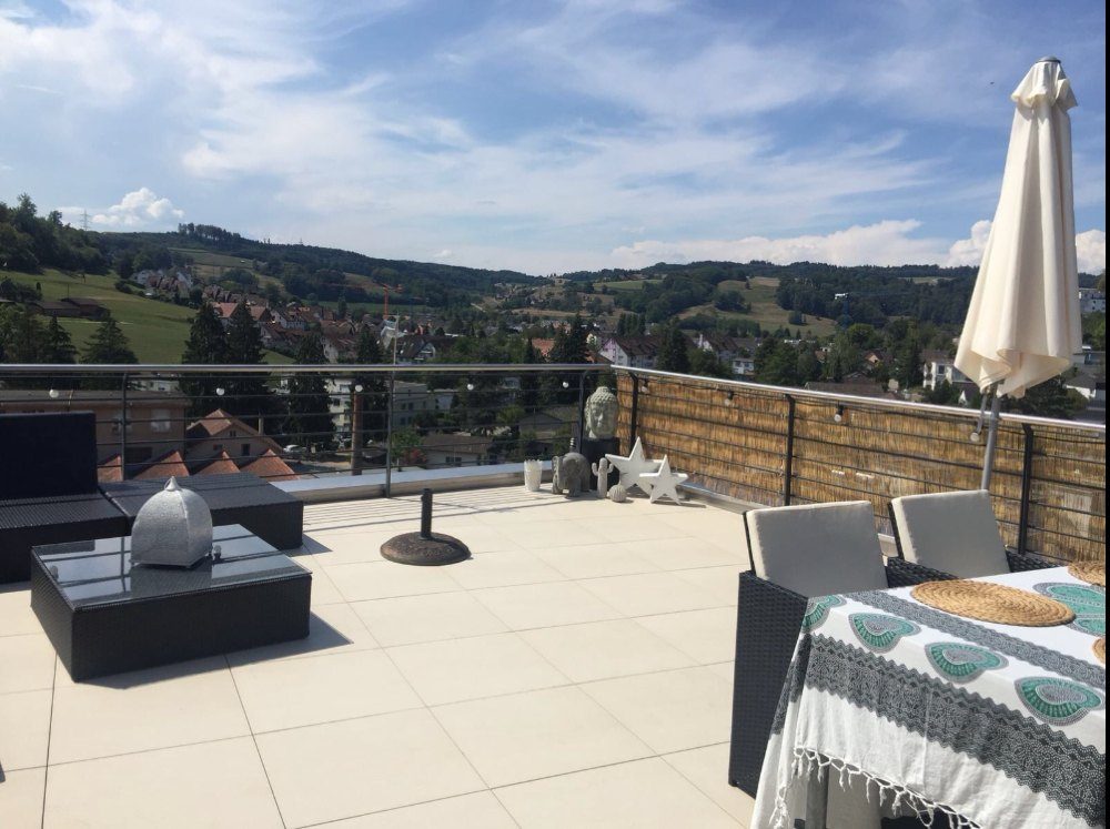 Grossformatige Platten auf einer Terrasse mit Sitzgruppe